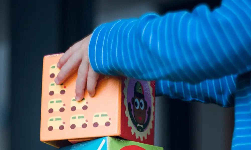 Bild mit Baby - Kind und orangem Bauklotz